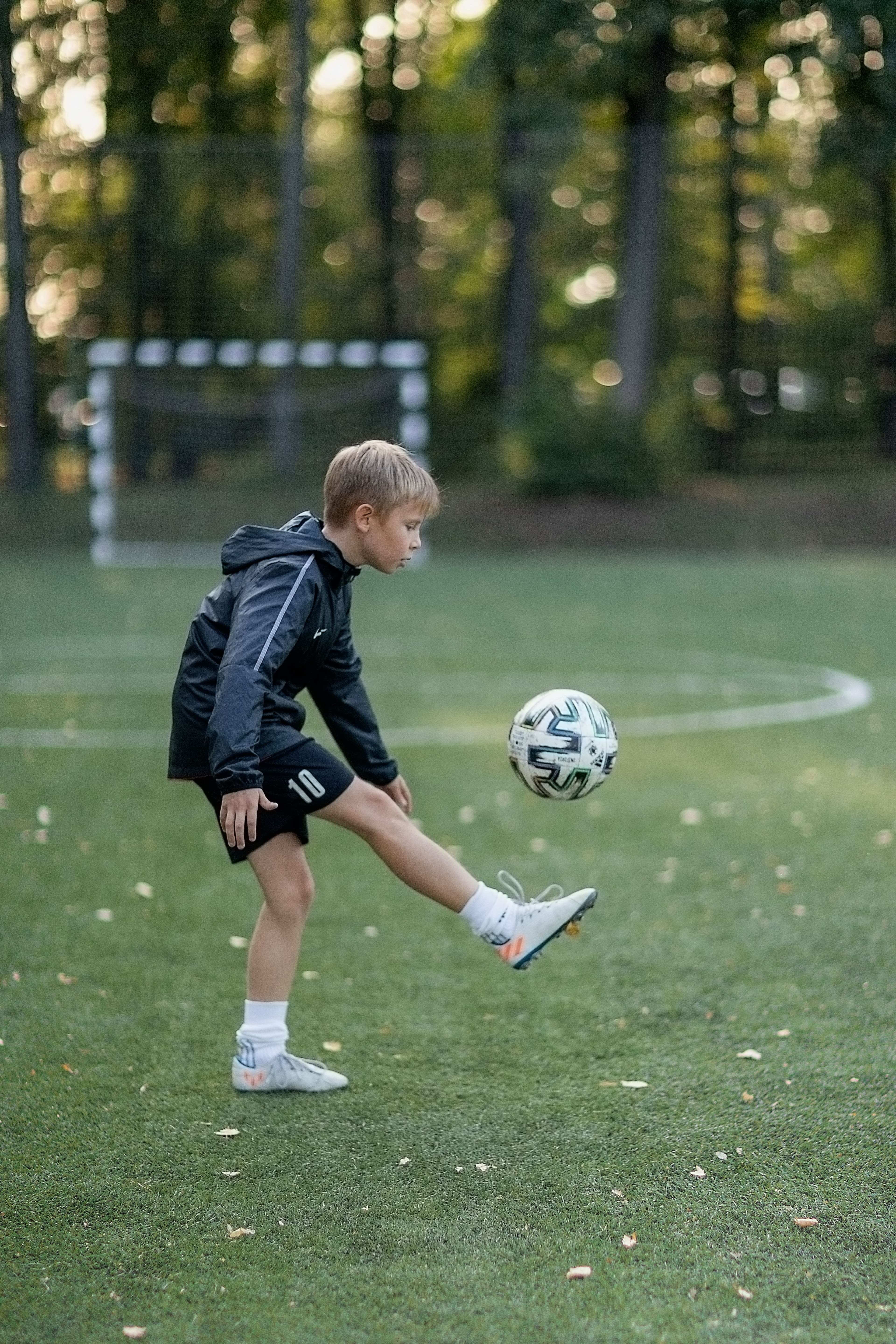 A child keeping a soccer ball up on a pitch